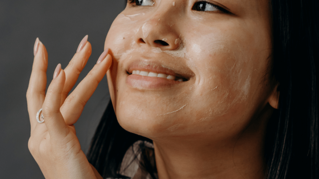 A person applying facial cream to their face