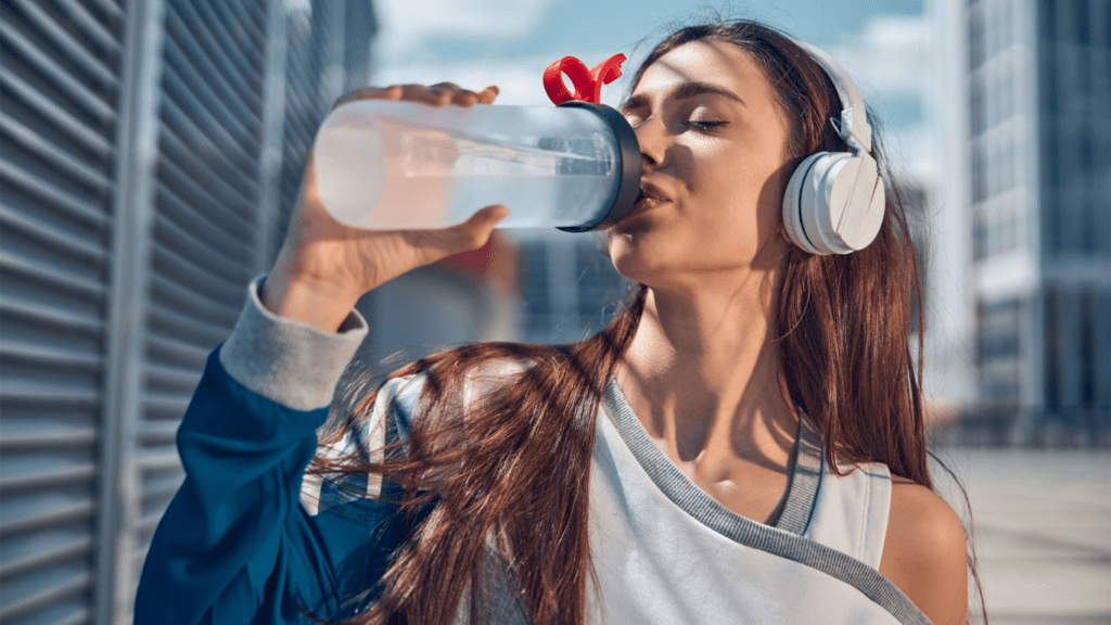 A person is drinking water from a water bottle