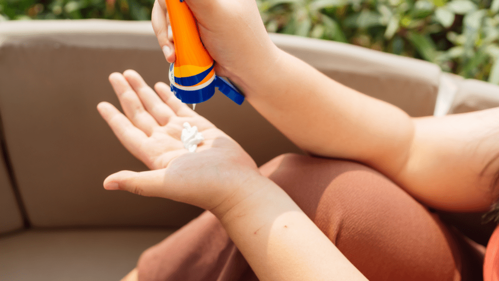 a person is applying sunscreen to their arm on the beach