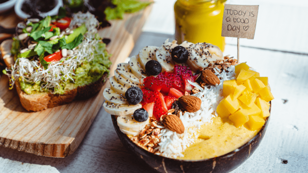 a bowl filled with fruit and vegetables on a wooden table