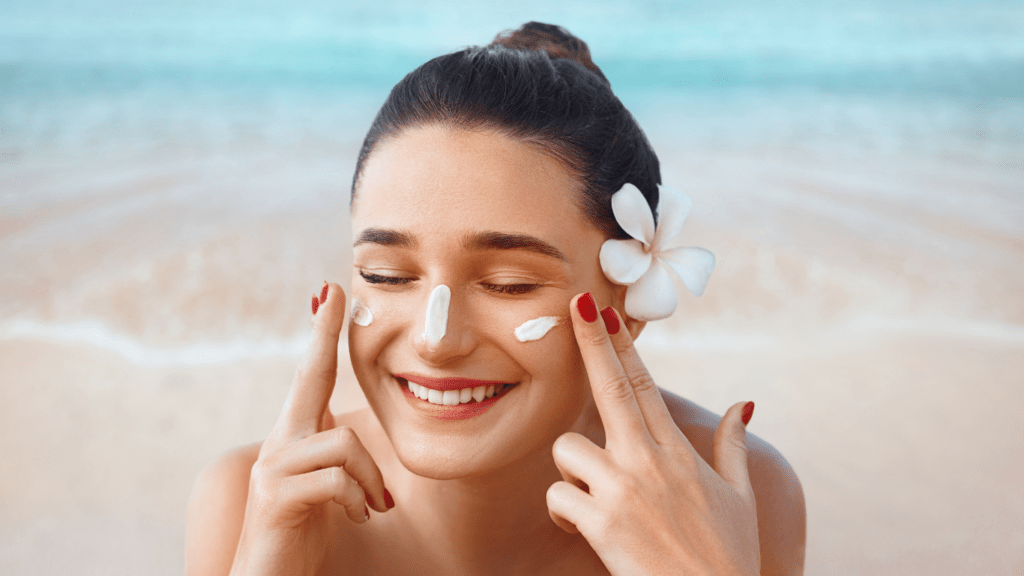 a person applying cream to their face on the beach