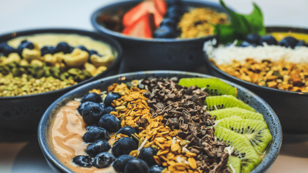 a bowl filled with fruit and vegetables on a wooden table