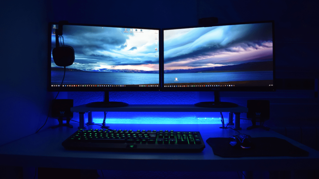 a desk with two monitors and a keyboard on it