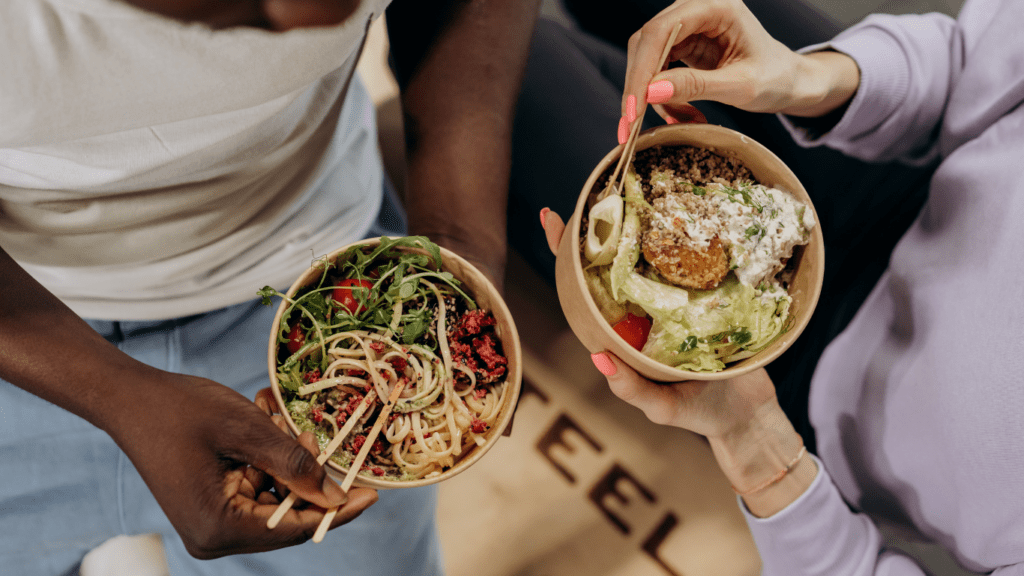 a person is holding a plate of food with fruit and vegetables on it