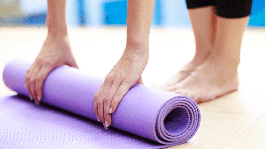 a person putting a yoga mat on the floor