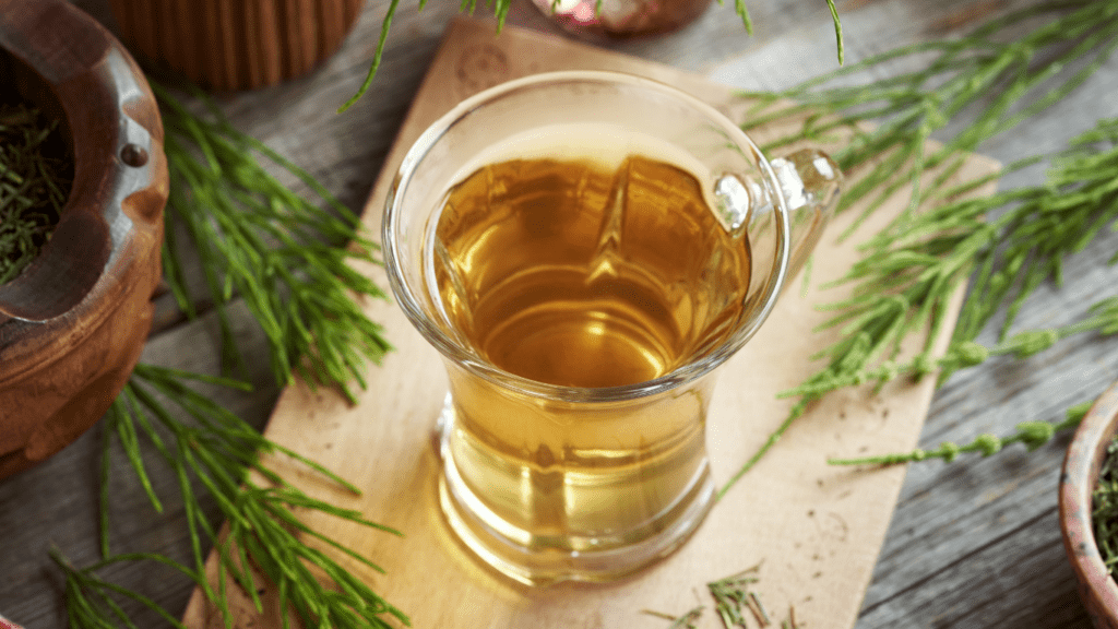 herbal tea with mint leaves in a glass cup on a wooden surface