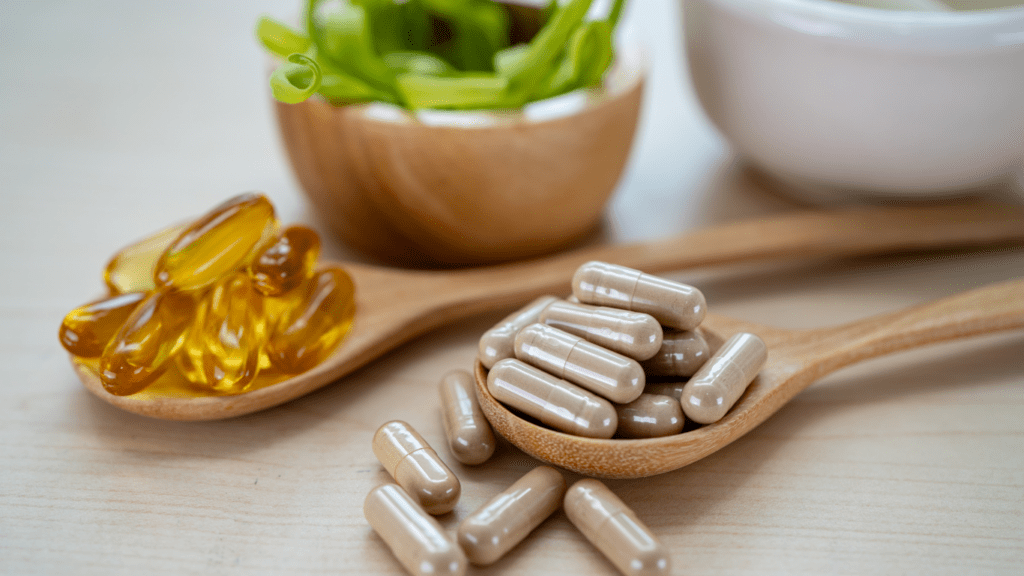 pills on a wooden spoon next to a mortar and pestle