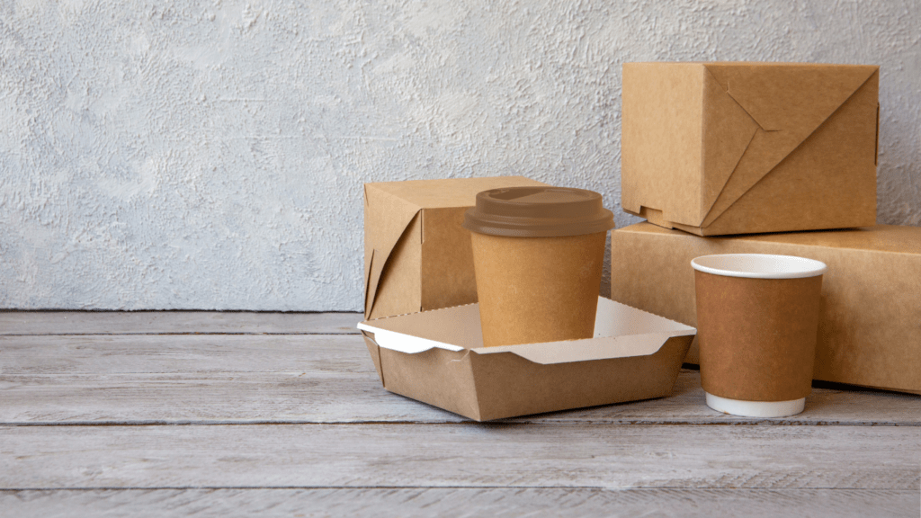 takeout boxes and coffee cups on a wooden table